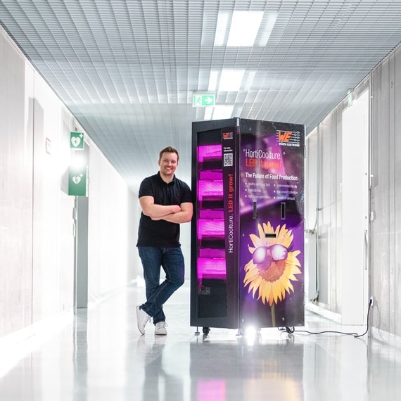 Man standing beside a horticulture cabinet