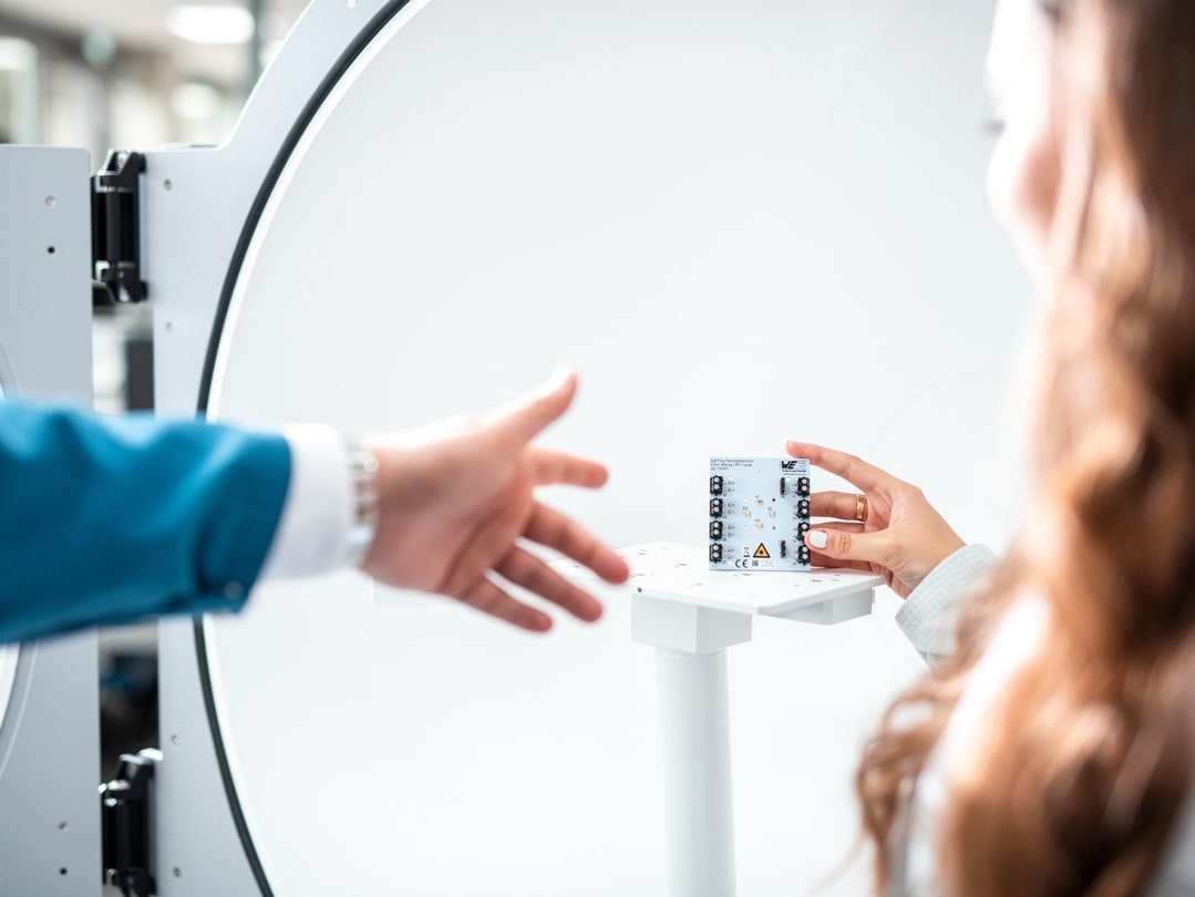 Hand reaching for a circuit board with components