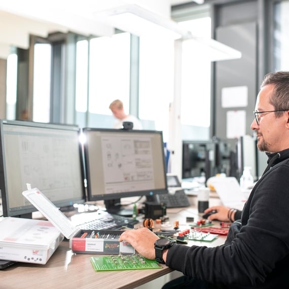 Mann arbeitet an einem Arbeitsplatz mit zwei Bildschirmen