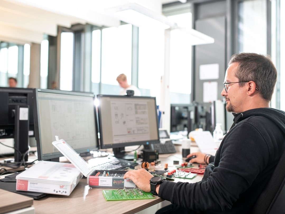 Man working at a desk with two screens