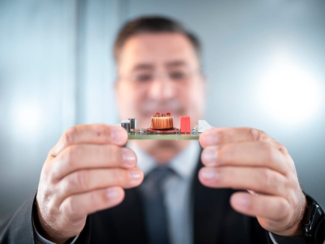 Man showing a circuit board to the camera