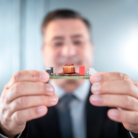 Man showing a circuit board to the camera