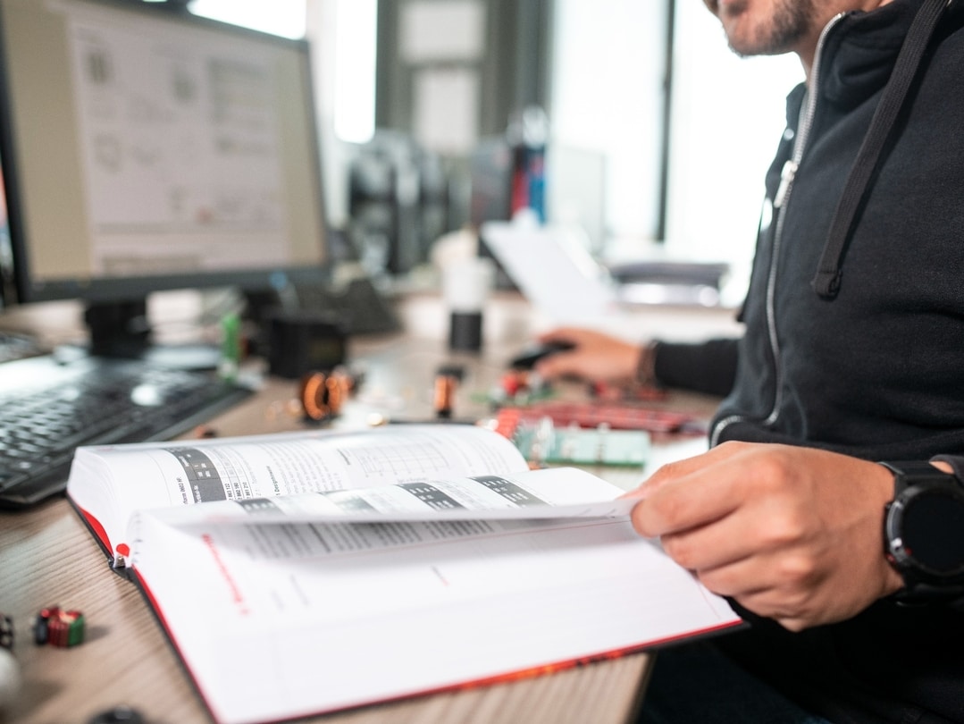 Man looking in a book the background shows two desks