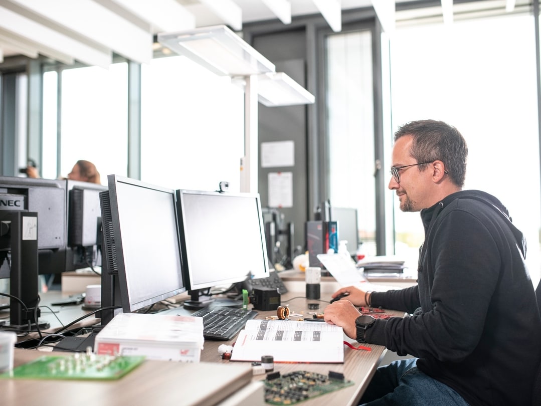 Man working at a desk with two screens