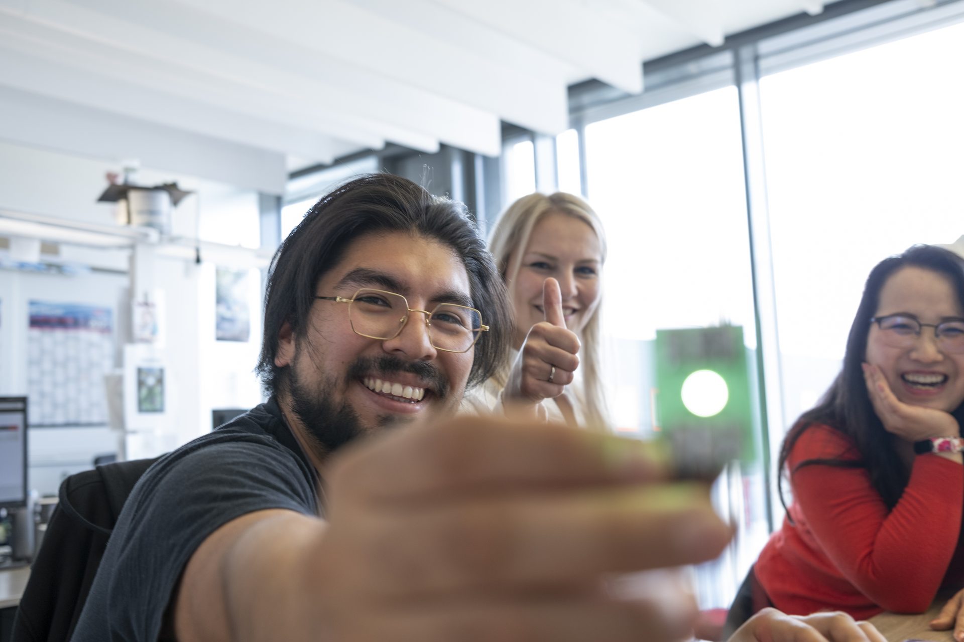 Ansprechpartner § Personen auf dem Bild und einer hält eine LED Lampe