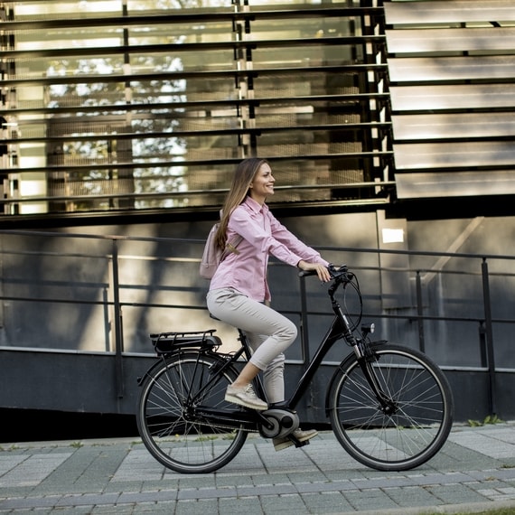 Eine Frau fährt mit einem elektrischen Fahrrad