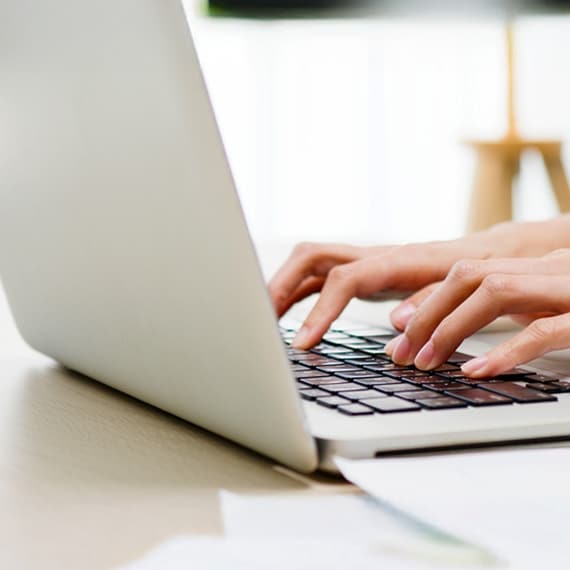 Laptop mit tippenden Händen
