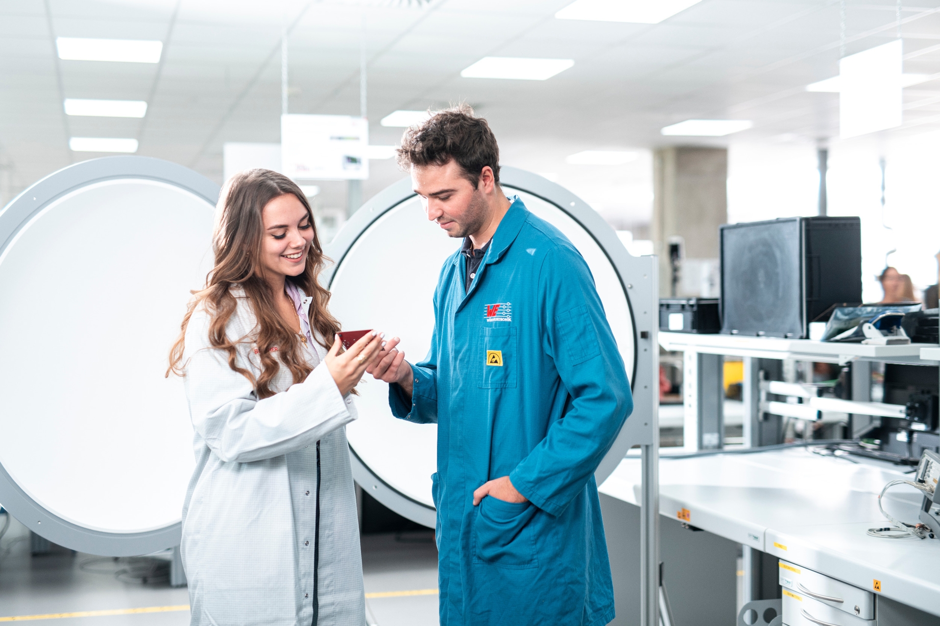 Material Compliance - Qualitätsprüfung 2 Personen in Laborkleidung die ein Produkt betrachten