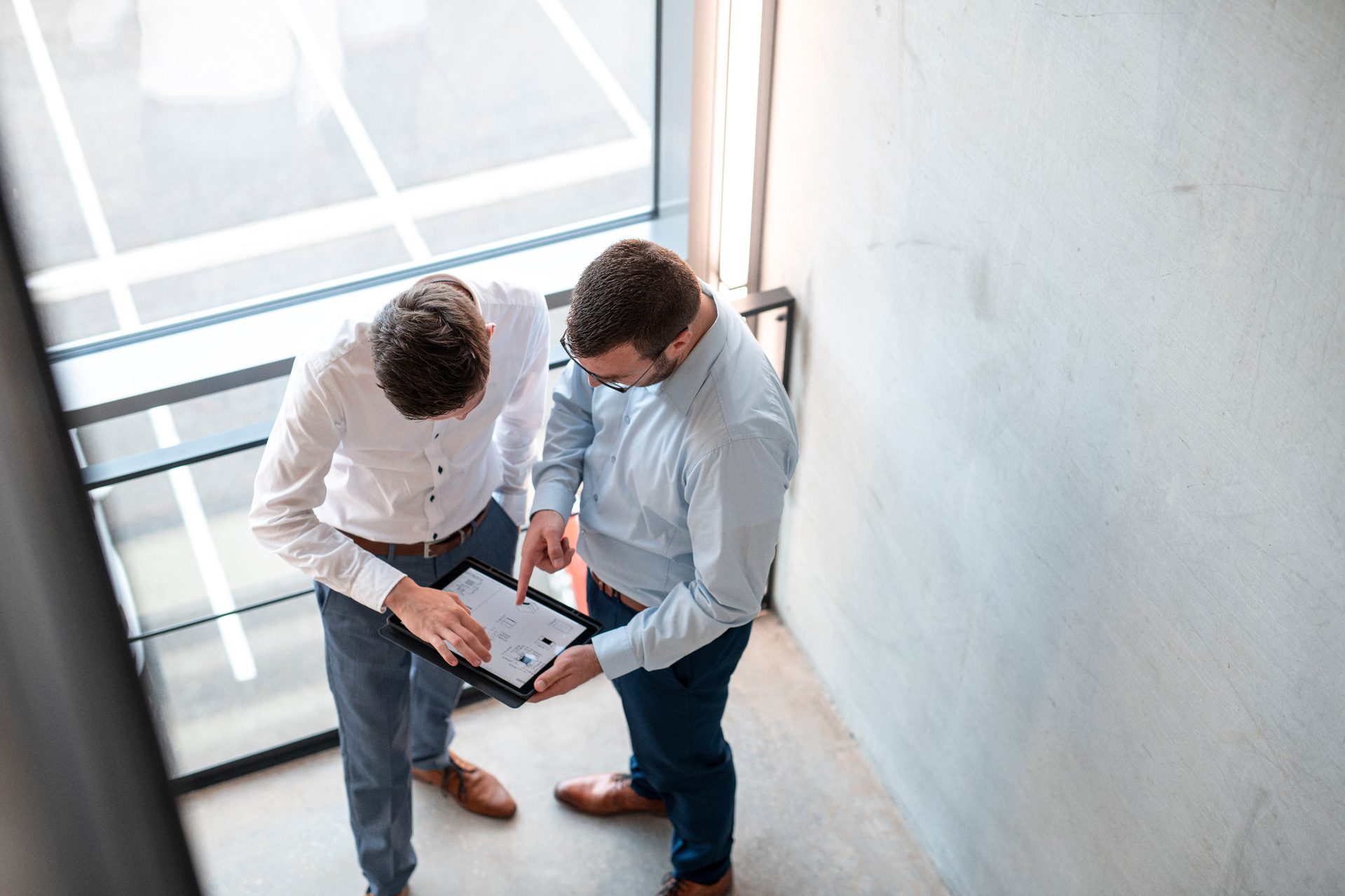 people tablet staircase Two people are discussing in the stairwell and looking at a tablet