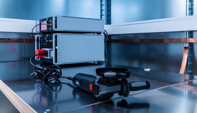 Measurement technology in the lab Technical measuring devices and a handheld tool are placed on a metal surface in a laboratory setting