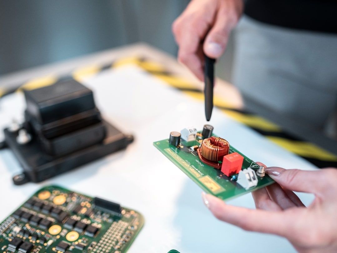 Man pointing on a component on a circuit board