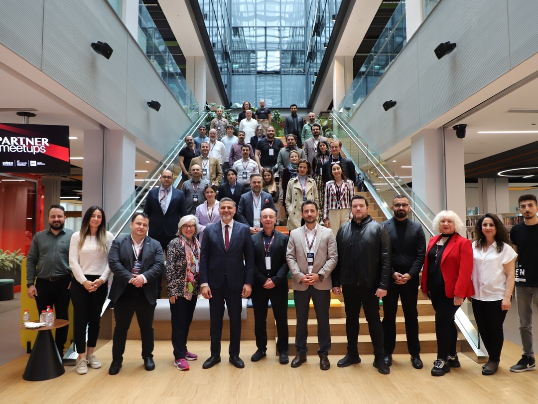 A large group of people are standing on a staircase and smiling at the camera.