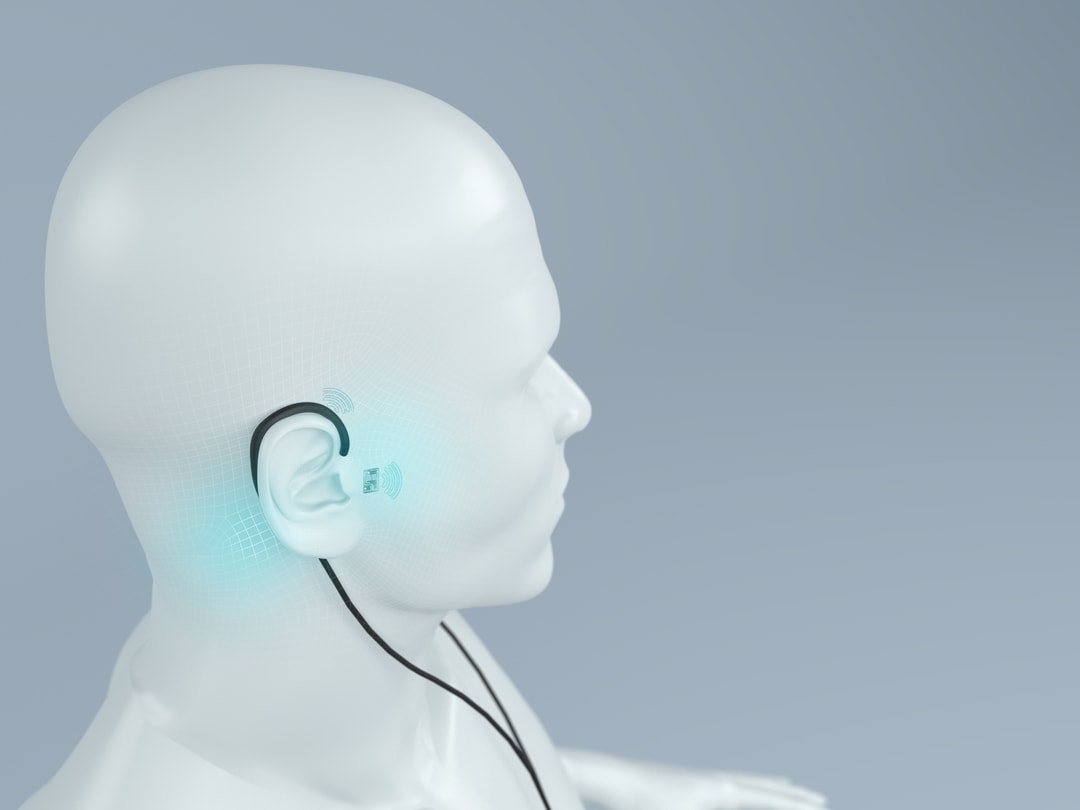 Fotomontage eines Kopfes mit Implantat im Ohr