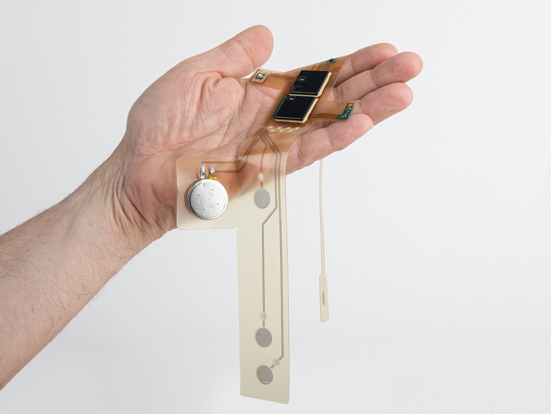 A hand holds a stretchable printed circuit board