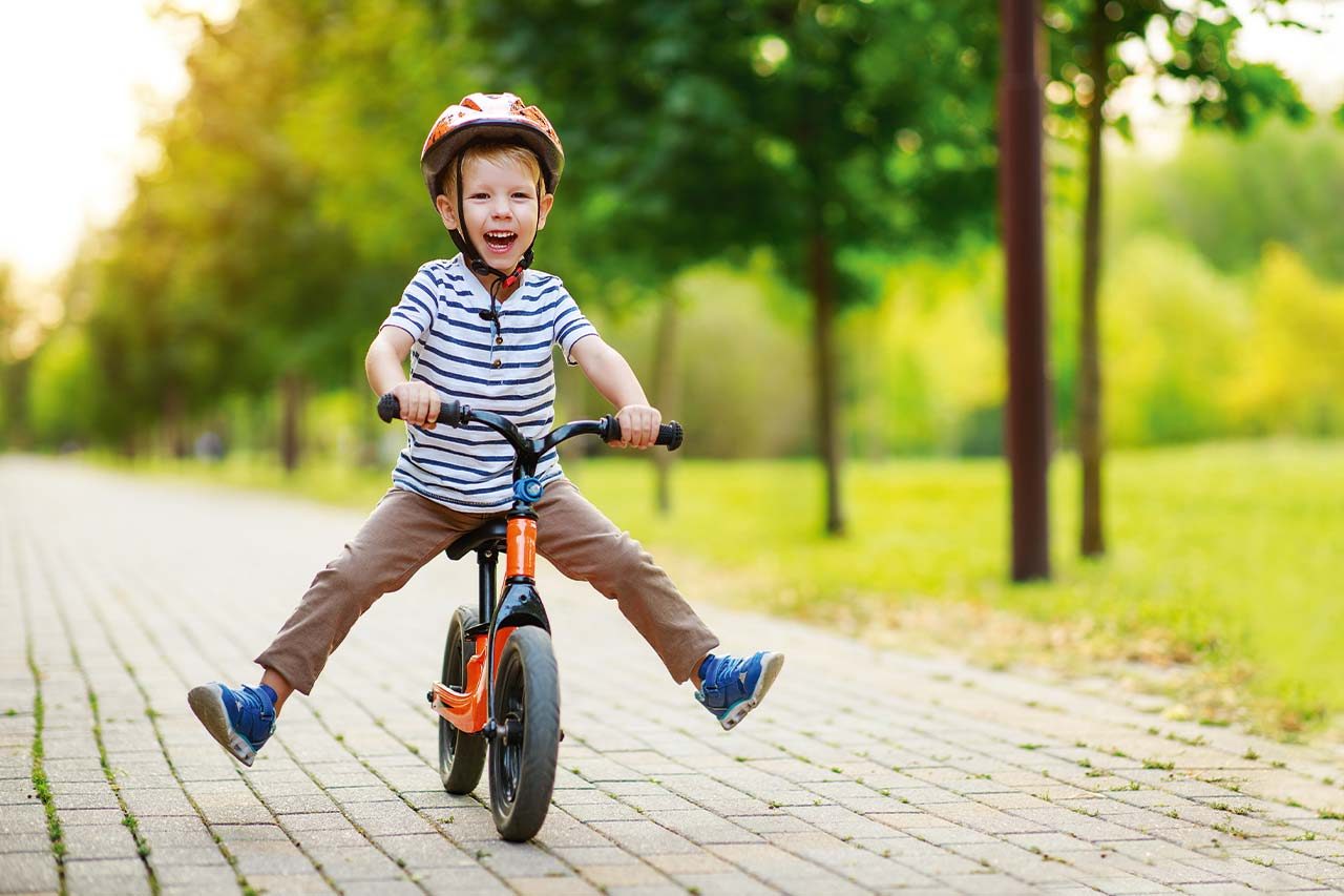 CBT WEBike 2024 Kinderprogramm Kleiner Junge fährt auf Laufrad und lacht dabei