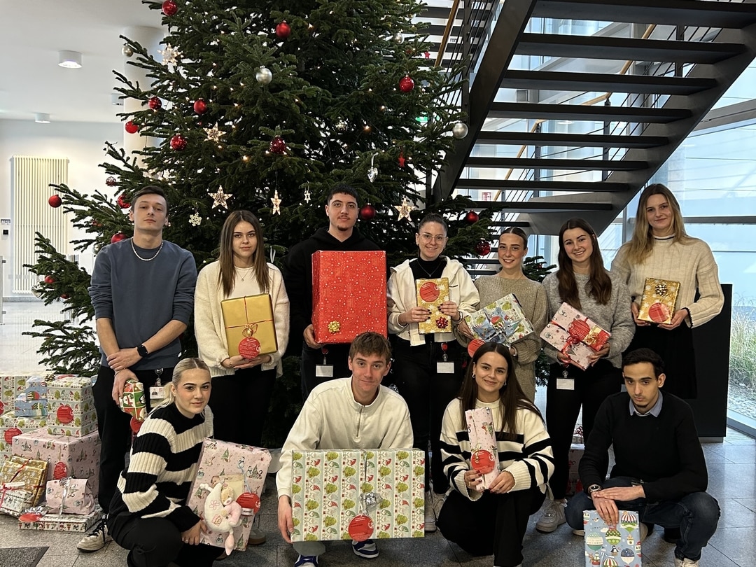 Group photo of the Wishing Tree campaign team in front of the Christmas tree at Würth Elektronik in Waldenburg.