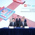 5 people on a stage, two setting on a desk with a pen in their hand and a presentation product picture in the background