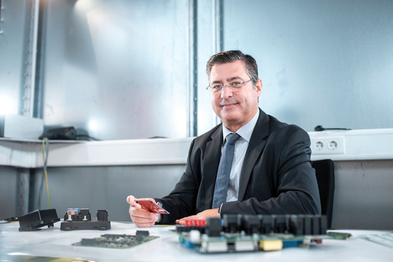 Male person sits in a laboratory in front of an electronic component
