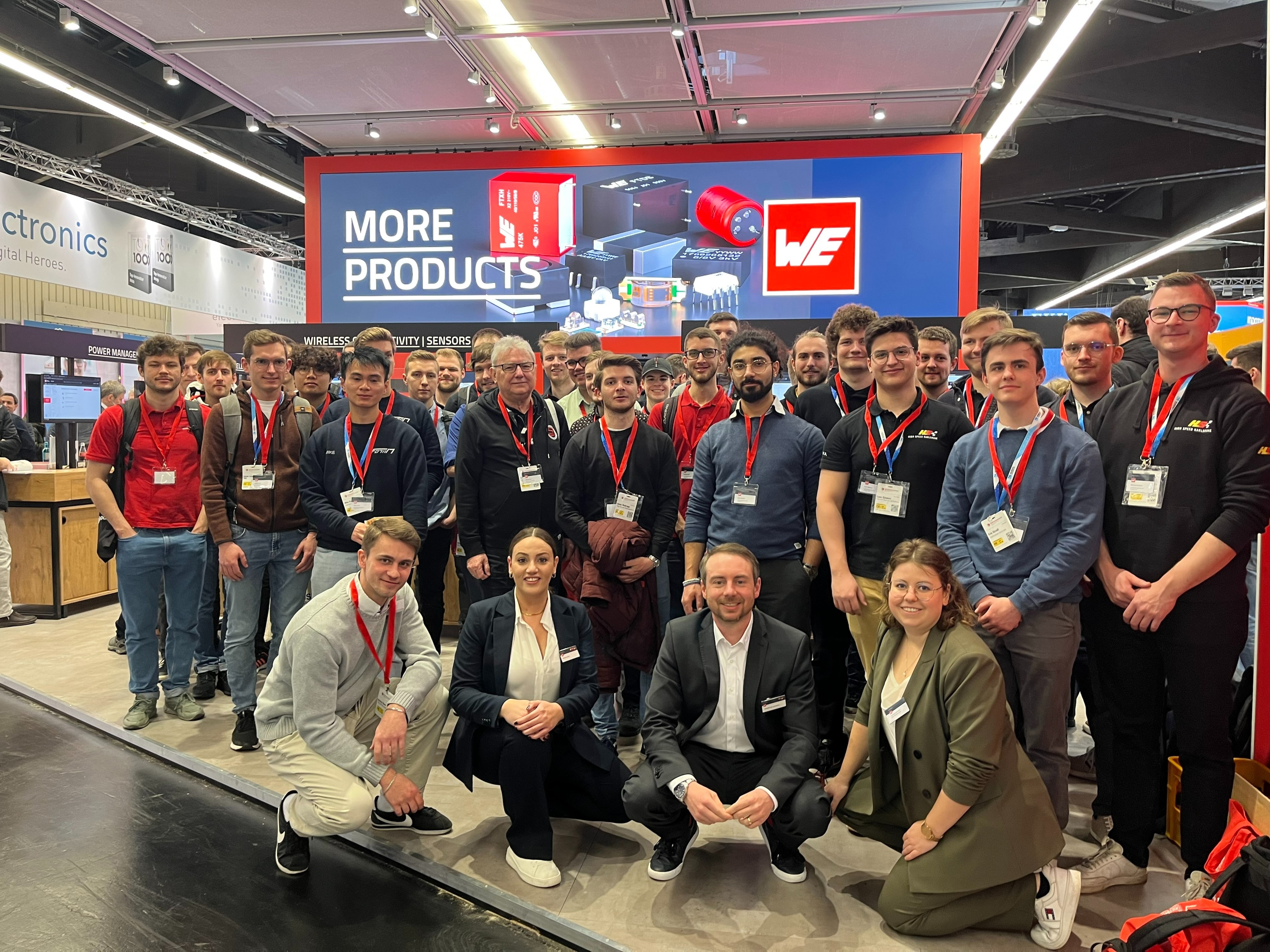 Group foto embedded world 2023 Many people with visitor cards standing in front of a booth