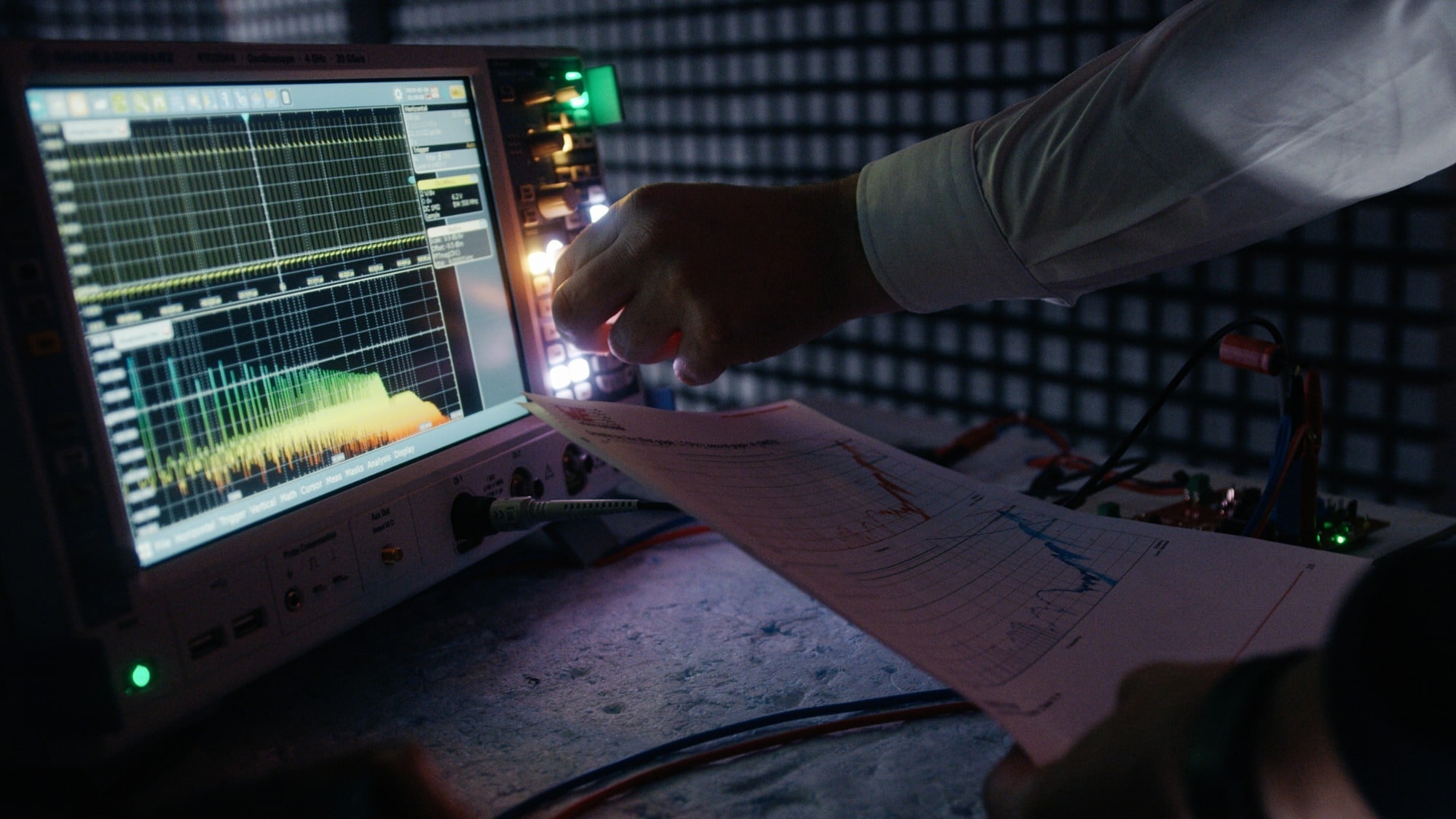 Person bedient ein Messgerät  Person bedient in der EMV-Kammer ein Messgerät