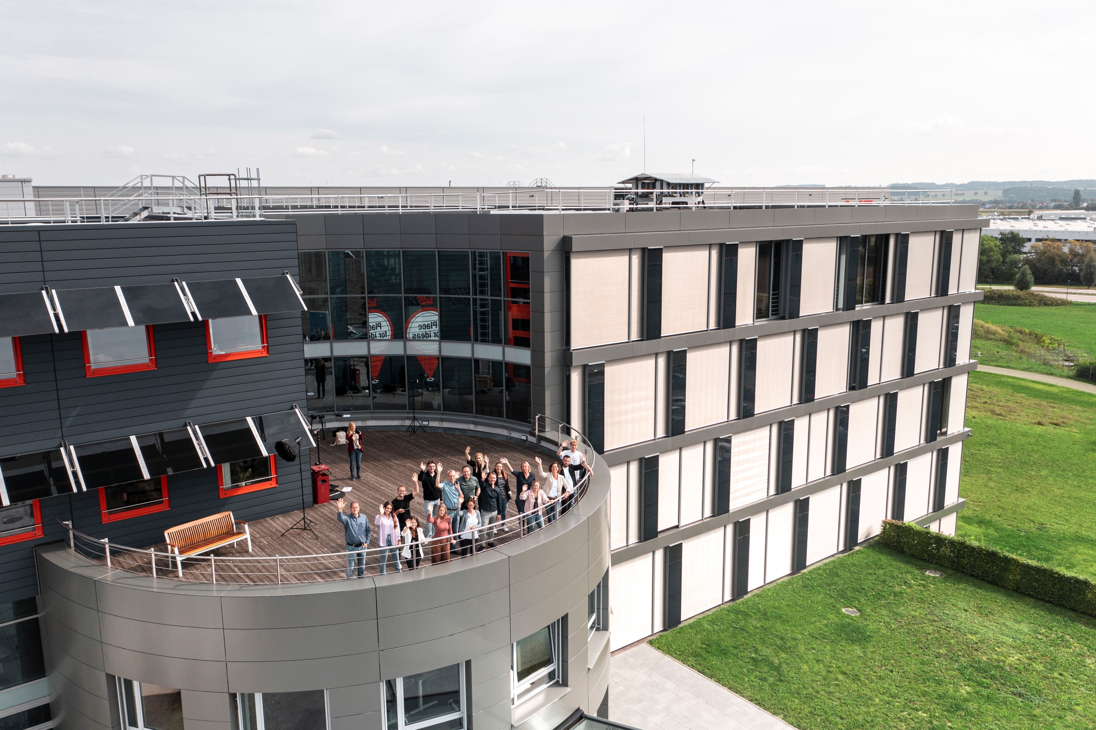 Würth Elektronik as an employer People waving from a roof terrace of the company building
