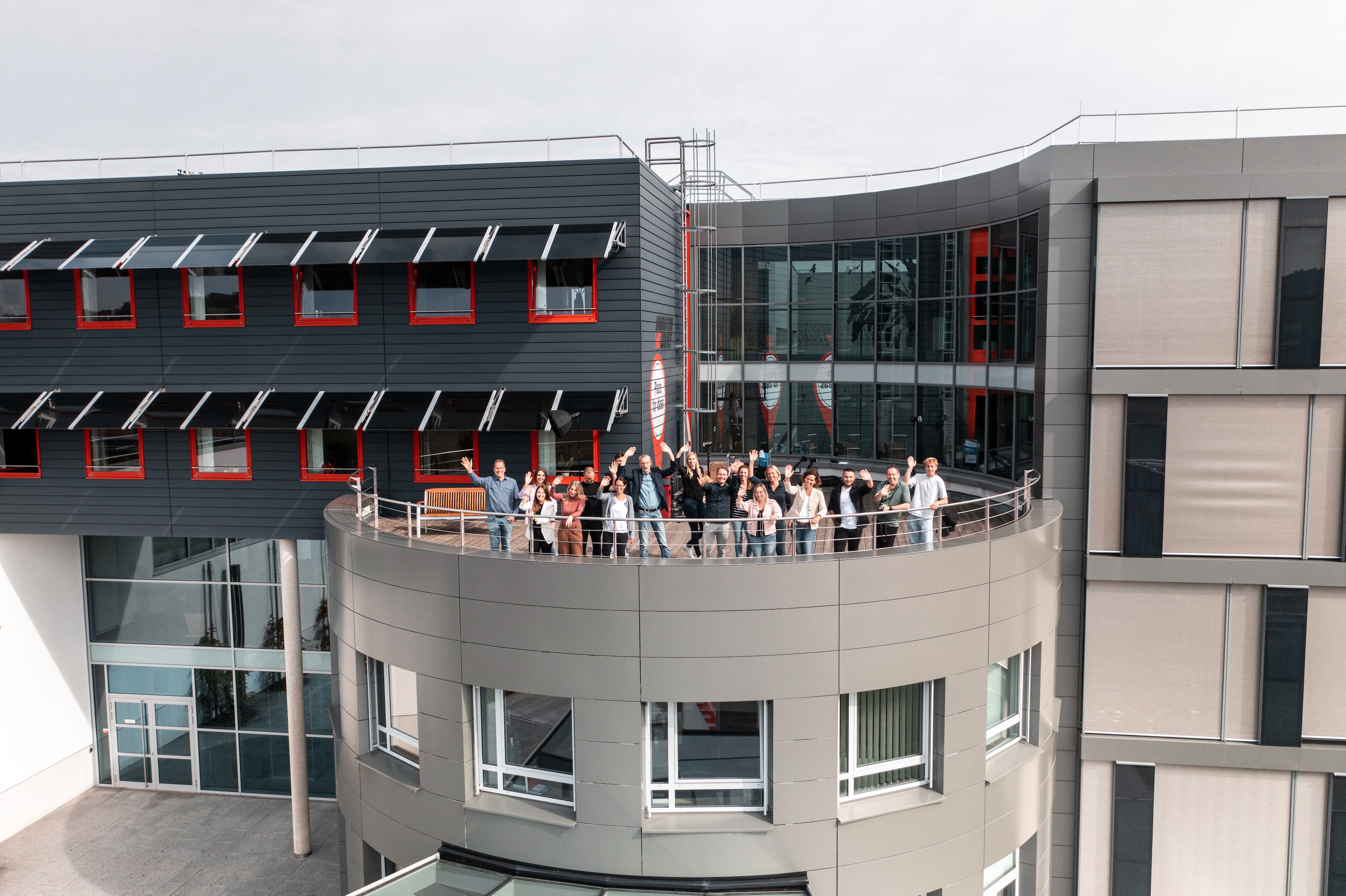 Career at Würth Elektronik Employees wave from the terrace of the building to