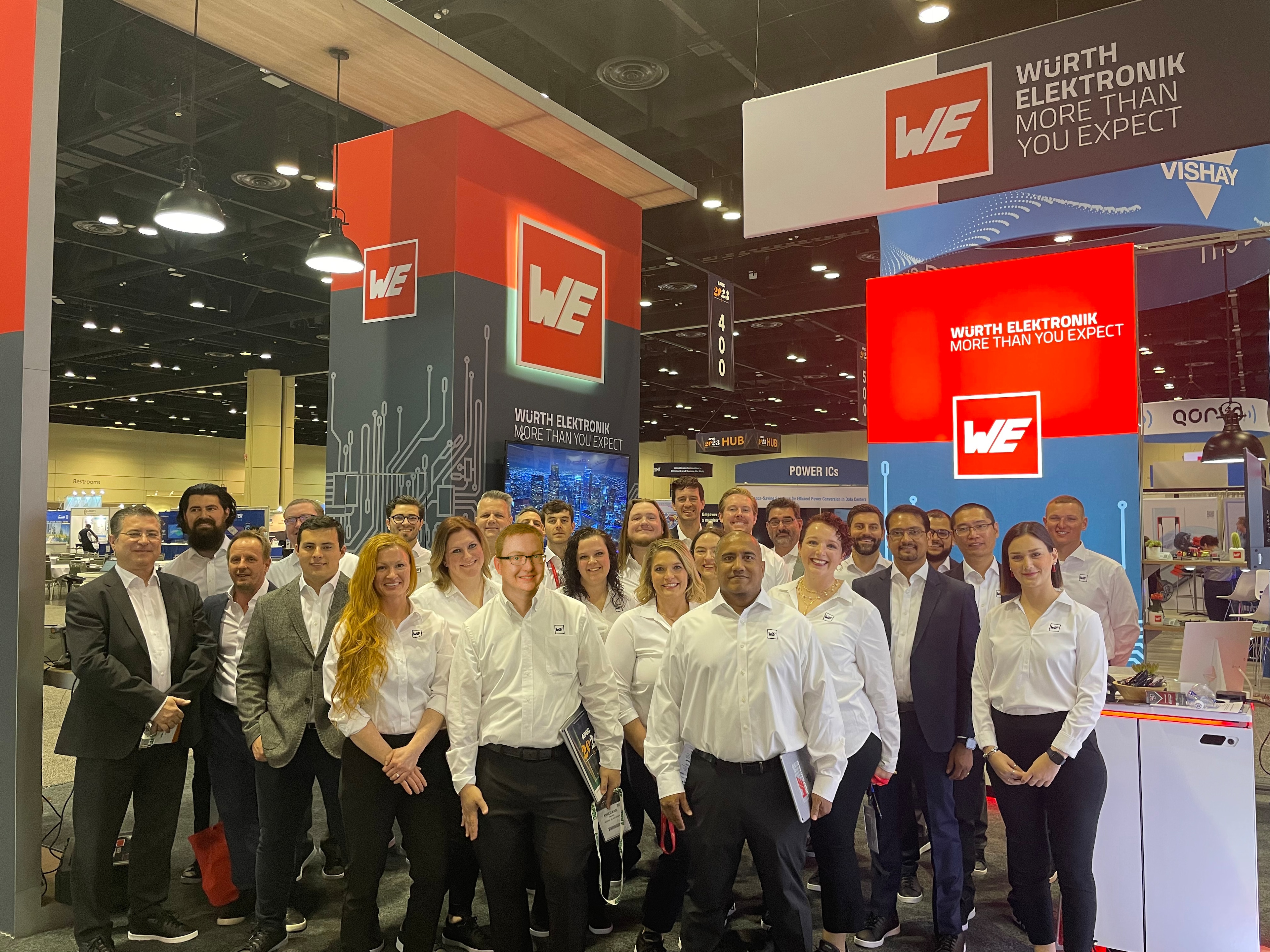 Group of people standing in white shirts and black pants at Würth Elektronik booth