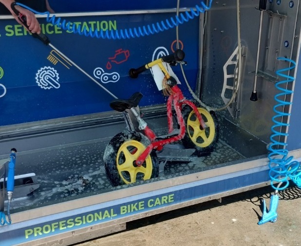 WEBike 2023 Radwasch-Box von easy power Laufrad eines jungen WEBike 2023 Teilnehmers wird in der Radwasch-Box gereinigt