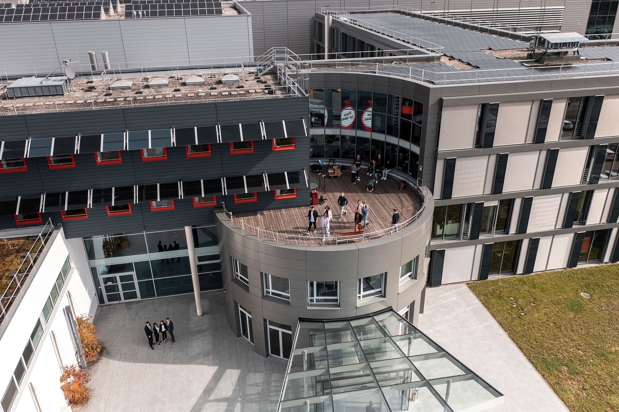 Karriere bei Würth Elektronik Mitarbeitende winken von der Terrasse des Gebäudes zu