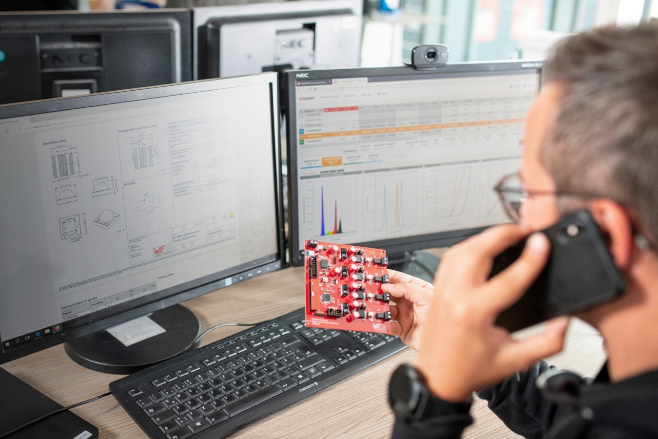 Contact support by phone Developer holds circuit board in hand and makes phone call
