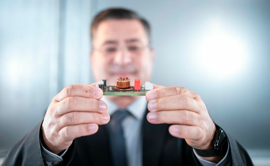 Developer holds circuit board in hand Developer holds circuit board in hand